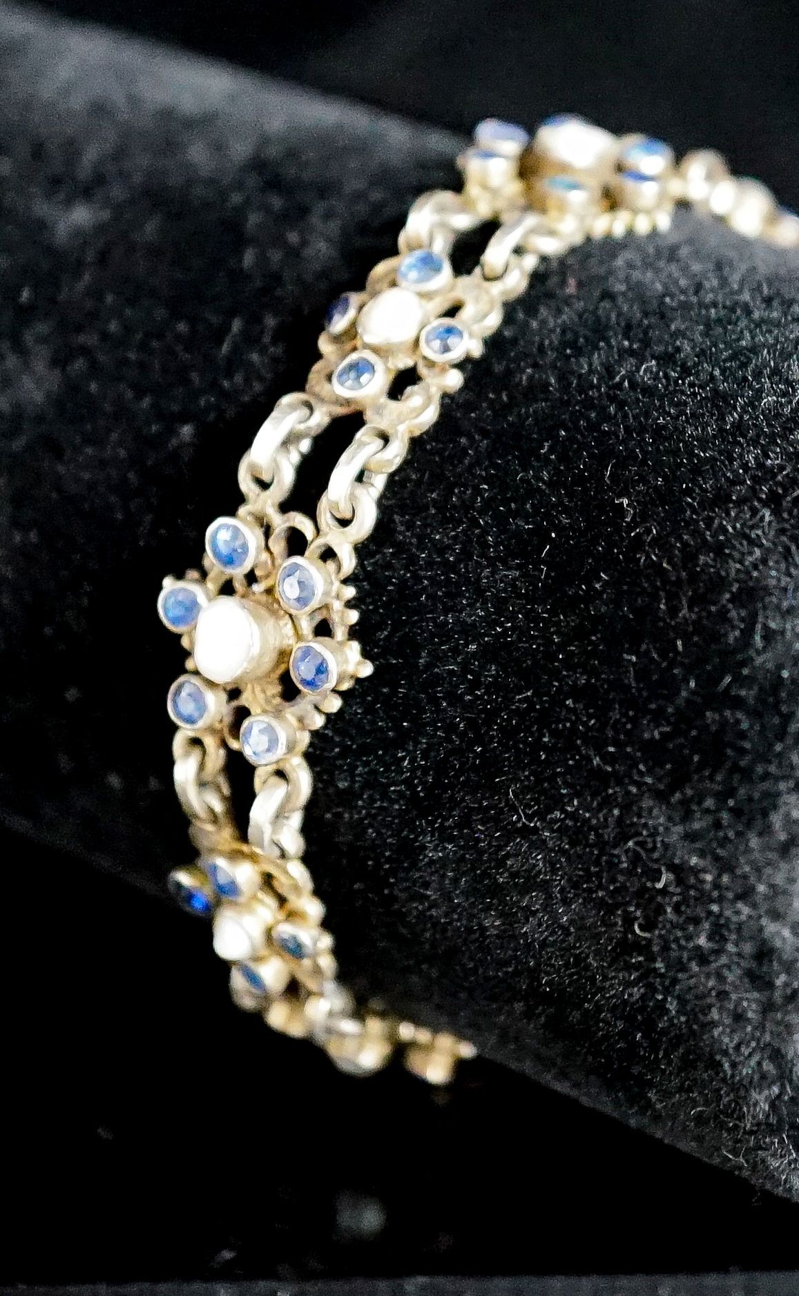 A continental gilt white metal, sapphire and split pearl flower head cluster set bracelet